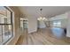 Bright, open-concept living room with hardwood floors, modern chandelier, and large picture window at 450 Pebble Blvd, Covington, GA 30016
