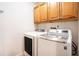Efficient laundry room features a modern, front-load washer and dryer and ample storage with wooden cabinets at 50 Biscayne Nw Dr # 5112, Atlanta, GA 30309