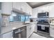 Modern kitchen featuring white cabinets, stainless steel appliances, and a view through to the dining room at 240 Renaissance Ne Pkwy # 112, Atlanta, GA 30308