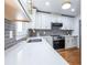 Bright kitchen featuring white cabinets, stainless steel appliances, quartz countertops, and hardwood floors at 2411 Charleston Oaks Ln, Decatur, GA 30030