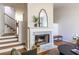 Elegant living room featuring a marble fireplace, hardwood floors, and modern decor with a staircase in view at 2411 Charleston Oaks Ln, Decatur, GA 30030