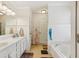 Bright bathroom featuring double vanity, soaking tub, and white wainscoting detail at 215 Morning Glory Rdg, Canton, GA 30115