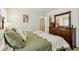 Comfortable bedroom featuring a plush bed with a green cover and a wooden dresser with a large mirror at 215 Morning Glory Rdg, Canton, GA 30115