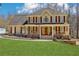Charming two-story home featuring a welcoming front porch with elegant columns and well-manicured lawn at 215 Morning Glory Rdg, Canton, GA 30115
