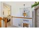 Bright hallway with decorative light fixture and view into an adjacent bedroom and the front door below at 215 Morning Glory Rdg, Canton, GA 30115