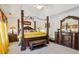Main bedroom featuring a four-poster bed, a marble top dresser, and bright yellow curtains at 215 Morning Glory Rdg, Canton, GA 30115