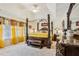 Main bedroom featuring a four-poster bed, a marble top dresser, and bright yellow curtains at 215 Morning Glory Rdg, Canton, GA 30115