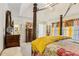 Main bedroom featuring a four-poster bed, a patterned quilt, and an attached bathroom at 215 Morning Glory Rdg, Canton, GA 30115