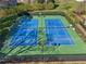 Overhead shot of well-maintained community tennis courts, lit for evening play, set in a verdant landscape at 215 Morning Glory Rdg, Canton, GA 30115