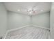 Bright bedroom with gray wood-look floors, ceiling fan, neutral paint, and baseboards at 3087 Colonial Way # J, Atlanta, GA 30341
