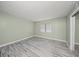Bright bedroom with a window, gray wood-look floors, neutral paint, and baseboards at 3087 Colonial Way # J, Atlanta, GA 30341