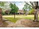 Community courtyard with lush green lawns, a decorative fountain, mature trees, and multiple seating areas at 3087 Colonial Way # J, Atlanta, GA 30341