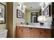 Bathroom featuring wood cabinets, granite counters, and a large mirror with vanity lighting at 3338 Peachtree Ne Rd # 2405, Atlanta, GA 30326