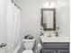 Bathroom features a shower with curtain, gray vanity, and decorative mirror at 2449 Suwanee Pointe Dr, Lawrenceville, GA 30043