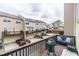 Back deck with grill, furniture, view of garage and other townhomes with dark cloudy skies at 2449 Suwanee Pointe Dr, Lawrenceville, GA 30043