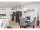 Dining area features a glass table, gray chairs, and a modern chandelier next to kitchen at 2449 Suwanee Pointe Dr, Lawrenceville, GA 30043
