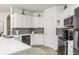 Kitchen featuring stainless steel appliances, gray backsplash, white cabinets, and white countertops at 2449 Suwanee Pointe Dr, Lawrenceville, GA 30043