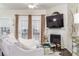 Cozy living room featuring a fireplace, large windows, and modern furniture at 2449 Suwanee Pointe Dr, Lawrenceville, GA 30043