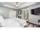 Large bedroom featuring a tray ceiling, ceiling fan, and adjacent bath and closet for optimal comfort at 2449 Suwanee Pointe Dr, Lawrenceville, GA 30043