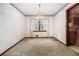 An empty dining room featuring carpeted floors, a window, a decorative chandelier, and floral wallpaper trim at 444 Wellington Way, Jonesboro, GA 30238