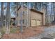 Home exterior featuring a two-car garage and wooded surroundings at 444 Wellington Way, Jonesboro, GA 30238