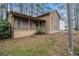 Exterior view of two-story home with a welcoming front porch and natural wood siding, nestled in a wooded lot at 444 Wellington Way, Jonesboro, GA 30238