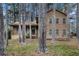 Two-story home featuring wood siding and surrounded by mature trees, creating a private, wooded setting at 444 Wellington Way, Jonesboro, GA 30238