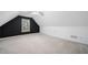 Spacious finished attic featuring an accent wall and large window at 455 Ellesmere Way, Buford, GA 30518