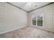 Cozy bedroom with patterned wallpaper, neutral carpet, and a bright window at 455 Ellesmere Way, Buford, GA 30518