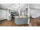 Open concept kitchen with stainless appliances, hardwood floors, vaulted ceilings and a spacious island at 455 Ellesmere Way, Buford, GA 30518