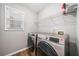 Convenient laundry room with modern appliances, shelving, and a window for natural light at 455 Ellesmere Way, Buford, GA 30518