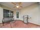 Covered patio with a brick floor, fan, grill, and comfortable seating at 455 Ellesmere Way, Buford, GA 30518