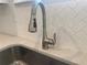 Close-up of a modern kitchen sink with stainless steel faucet and white subway tile backsplash at 871 Pineberry Ct, Grayson, GA 30017