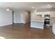 Open-concept living space flows to the kitchen featuring hardwood floors, island, and stainless appliances at 871 Pineberry Ct, Grayson, GA 30017