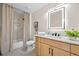 Bathroom featuring a shower with marble tile, a wood vanity with a modern illuminated mirror at 1288 Gate Post Ln, Powder Springs, GA 30127