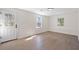 Bright, airy living room with hardwood floors, white walls, and natural light from windows and glass door at 1288 Gate Post Ln, Powder Springs, GA 30127