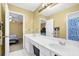 Bathroom featuring double sinks with white cabinetry, and a doorway view into the bedroom at 1621 Telfair Chase Way, Lawrenceville, GA 30043