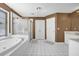 Luxurious bathroom featuring a soaking tub, separate shower, and tiled floors at 1621 Telfair Chase Way, Lawrenceville, GA 30043