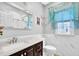 Bright bathroom with marble-like walls, a dark vanity, and a window with lace curtains at 1621 Telfair Chase Way, Lawrenceville, GA 30043