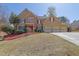 Charming two-story home featuring a three-car garage, stone accents, and a vibrant red front door at 1621 Telfair Chase Way, Lawrenceville, GA 30043