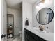 Bright bathroom features a modern vanity with a sink and a round mirror at 245 Raleigh Way, Villa Rica, GA 30180