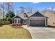 Charming home with two-car garage, dark siding, well-manicured lawn, and beautiful landscaping at 245 Raleigh Way, Villa Rica, GA 30180