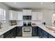 Well-lit kitchen features stainless steel appliances, black and white cabinetry, and marble countertops at 245 Raleigh Way, Villa Rica, GA 30180
