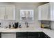Bright kitchen features undermount sink, gooseneck faucet, white countertops, and stainless steel appliances at 245 Raleigh Way, Villa Rica, GA 30180