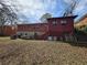 View of the home's backyard featuring a brick and stone exterior under a bright blue sky at 1404 Aniwaka Sw Ave, Atlanta, GA 30311
