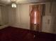 Bedroom with dark red carpet, large window, and basic lighting at 1404 Aniwaka Sw Ave, Atlanta, GA 30311