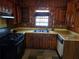 Traditional kitchen with wood cabinets, a double basin sink, and black appliances at 1404 Aniwaka Sw Ave, Atlanta, GA 30311