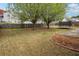 Large backyard with a mix of grass and dirt, surrounded by a wood fence and mature trees at 2172 Creekview Trl, Decatur, GA 30035