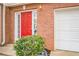A bright red front door, brick facade, and attached garage create a welcoming entryway at 3302 Waldrop Trl, Decatur, GA 30034