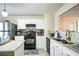 Bright kitchen featuring stainless steel appliances, white cabinets, black appliances and a center island at 3302 Waldrop Trl, Decatur, GA 30034
